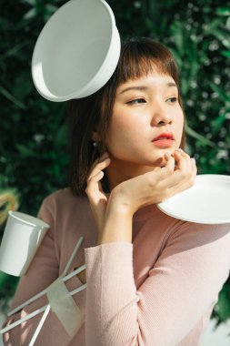 Plastik atık konsepti. Yakın plan - Asyalı Taylandlı kısa saçlı, yeşil arka planda plastik atık aksesuarlı kadın.