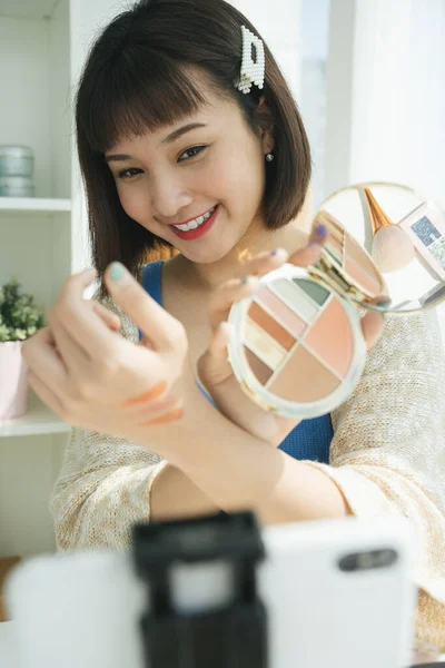 아리따운 아시아인아름다운 블로거가 스마트폰으로 화장품 제품을 라이브로 합니다 온라인 미디어 — 스톡 사진