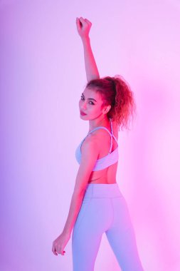 Arka plan - Neon ışıklı arka planda kollarını havaya kaldıran Asyalı genç bir kadın.