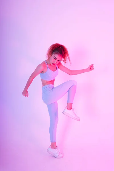 穿着运动服的漂亮的年轻亚洲女人在霓虹灯下伸展身体 体操健身概念 — 图库照片