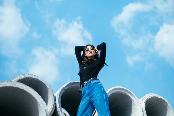 Fashionista Mädchen Schwarzem Pullover Und Jeans Steht Auf Großen Betonröhren — Stockfoto