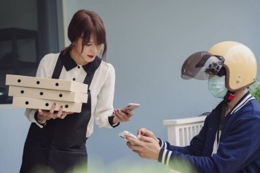 Pizza kutusunun parasını ödeyen Asyalı kadın akıllı telefondan pizzacıya başvurmuş. Tarama ödeniyor.