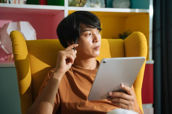 身穿休闲装的亚洲商人坐在沙发上 在家里用数字笔记本电脑工作 — 图库照片