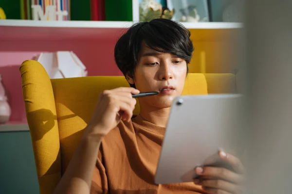 身穿休闲装的亚洲商人坐在沙发上 在家里用数字笔记本电脑工作 — 图库照片