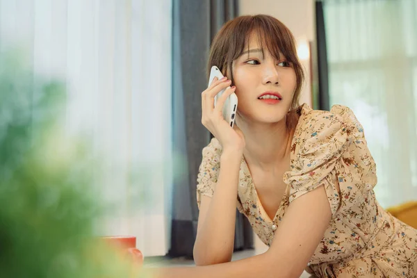 自宅でオンラインサービスのためのスマートフォンを使用して美しいアジアのタイ人女性 — ストック写真
