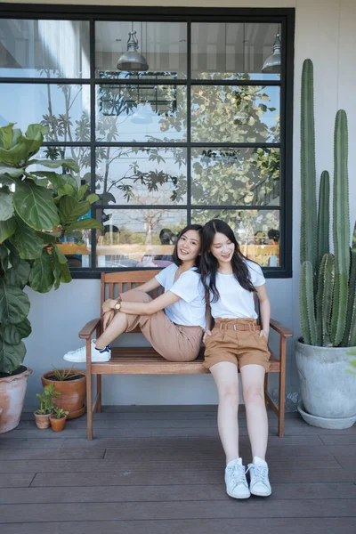 Dwie Dziewczyny Białym Shircie Siedzące Przed Kawiarnią Drewnianej Ławce Obok — Zdjęcie stockowe