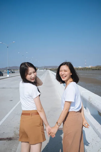 Szczęśliwe Dwie Dziewczyny Białej Koszulce Spacerują Razem Moście Słońcu Błękitnym — Zdjęcie stockowe