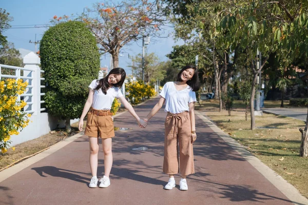 Dwie Dziewczyny Białej Koszulce Stojące Trzymające Się Ręce Ścieżce Biegania — Zdjęcie stockowe