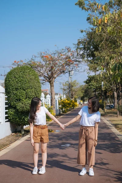 Dwie Dziewczyny Białej Koszulce Stojące Trzymające Się Ręce Ścieżce Biegania — Zdjęcie stockowe