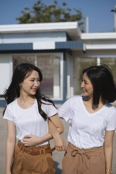 Δύο Κορίτσια Λευκό Μπλουζάκι Περπατούν Χέρια Δεμένα Στο Φως Του — Φωτογραφία Αρχείου