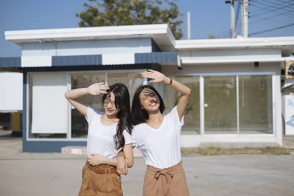 Dvě Dívky Bílém Tričku Stojící Propletenýma Rukama Zvedají Ruce Chrání — Stock fotografie