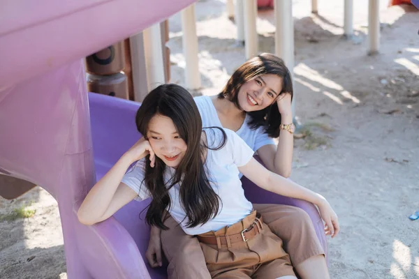 Duas Garotas Camiseta Branca Sentadas Final Slider Playground Juntas Parque — Fotografia de Stock