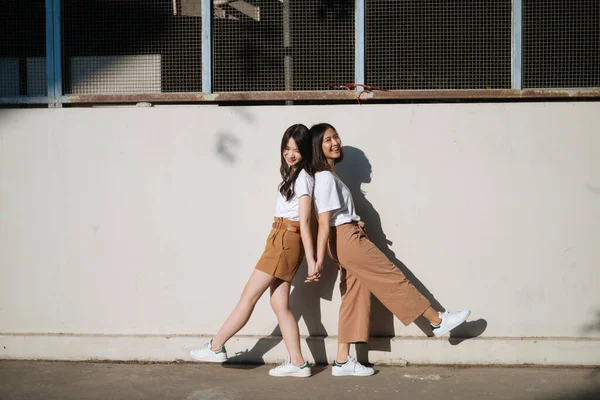 Duas Raparigas Shirt Branca Calças Castanhas Juntas Luz Sol Parede — Fotografia de Stock