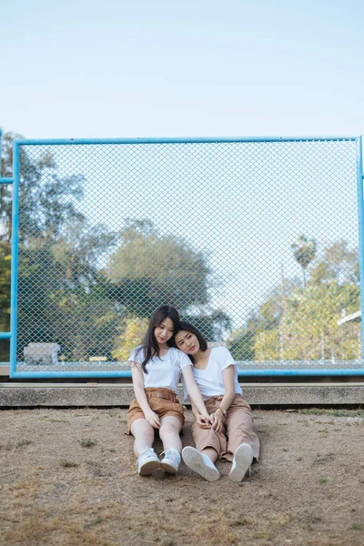 Two Girls White Shirt Brown Pants Sitting Ground Next Blue — Stock Photo, Image