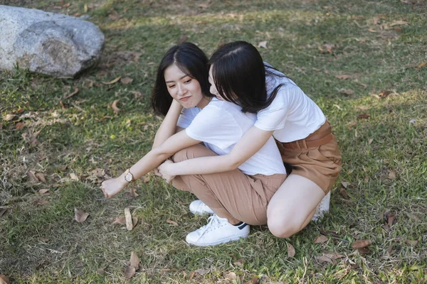 Dos Chicas Camiseta Blanca Pantalones Marrones Sentados Hierba Chica Har — Foto de Stock