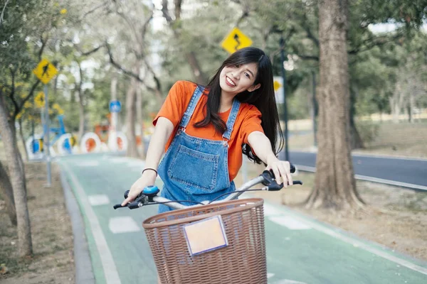 Hosszú Hajú Lány Narancssárga Pólóban Farmer Pulóverben Biciklizik Parkban Kerékpársávban — Stock Fotó