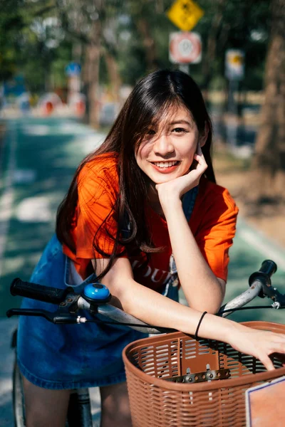 Długie Włosy Dziewczyna Pomarańczowej Koszulce Dżinsy Sweter Zatrzymać Jej Rower — Zdjęcie stockowe