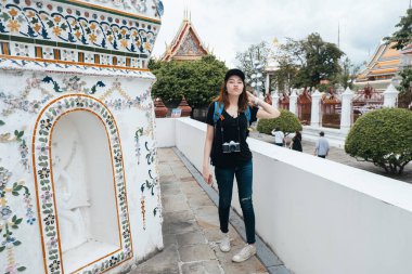 Genç Asyalı sırt çantalı kadının portresi Wat Arun Tapınağı 'nı gezmenin keyfini çıkar..