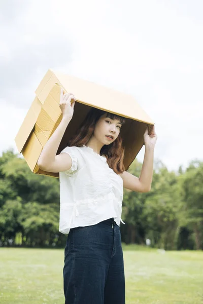 年轻的亚洲女人 嬉皮士卷发 头戴白衬衫 头戴纸板箱 — 图库照片