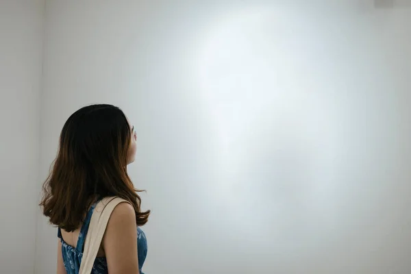 女性見ます空の白いフレームでアートギャラリー — ストック写真