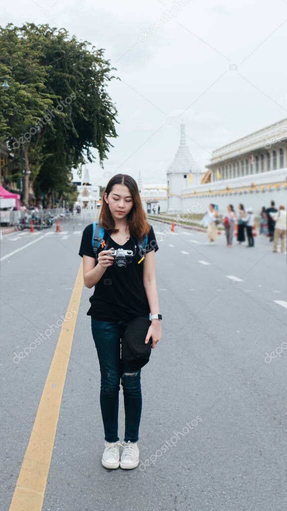 Portrait of young asian woman travel in Bangkok standing on the road near wat arun area.