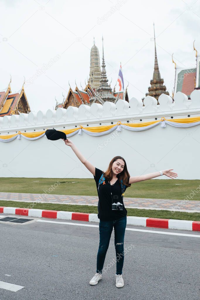 Portrait of young asian woman travel in Bangkok standing on the road near wat arun area.