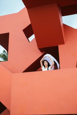 Bangsaen 'deki kırmızı yapının üzerinde beyaz peçeli Asyalı uzun saçlı kadın gelinin portresi..