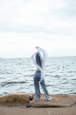 Arka plan - Sahilde beyaz peçeli, Asyalı genç, uzun saçlı, seksi bir kadının portresi.