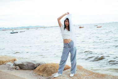 Sahilde beyaz peçeli, uzun siyah saçlı seksi Asyalı kadın gelinin portresi..