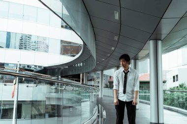 Umutsuz Taylandlı iş adamı şehirde bir patikada duruyor. Yorgun Taylandlı işadamı.