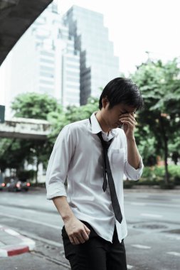 Bangkok 'ta yürürken işini kaybettikten sonra üzgün işadamı aklını kaybetti. Ciddi işadamı işi bıraktıktan sonra üst geçitte duruyor.