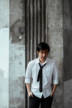 Lekeli duvarda duran takım elbiseli, acınası iş adamı. Depresyonla duvara yaslanmış gibi. Kırsal duvar.