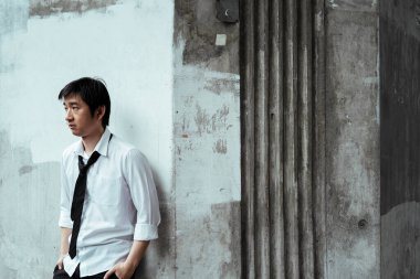 Lekeli duvarda duran takım elbiseli, acınası iş adamı. Depresyonla duvara yaslanmış gibi. Kırsal duvar.