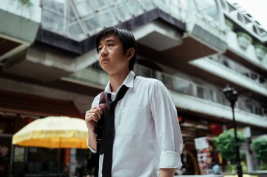 Asyalı iş adamı şehirde yürüyor ve yeni bir iş buluyor.