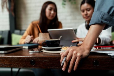 Patronu izlerken iki genç bayan tablet üzerinde birlikte çalışıyor. Günlük yaşamda modern teknolojiler. İki iş kadını iş arkadaşı dizüstü bilgisayarda birlikte çalışmayı tartışıyor ve yeni başladıkları iş için online fikirlerini açıklıyorlar.. 