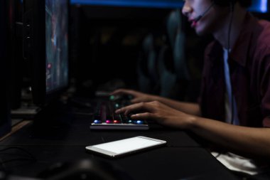 İnternet kafede oyun oynayan Asyalı oyuncu yanına beyaz ekran akıllı telefon koymuş..