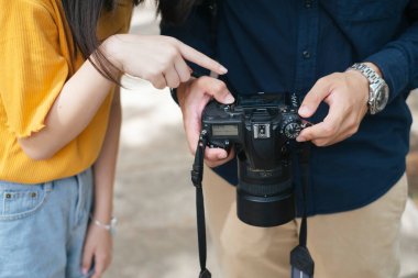 Fotoğrafçı ve modelin kesilmiş görüntüleri, çektikleri fotoğrafa, fotoğrafın modeline bakıyorlar..