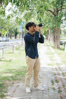 Erkek fotoğrafçı, yaprak, ağaç ve gökyüzünün fotoğrafını çek..