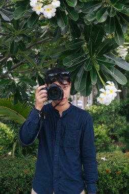 Plumeria ağacının altında çekilen erkek kamera..