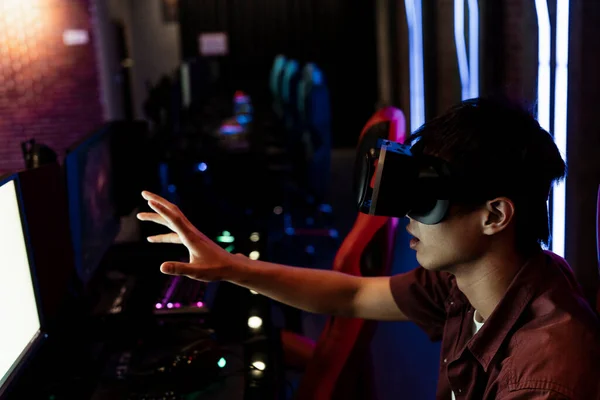 在网吧里戴着虚拟现实护目镜的亚洲年轻人 Vr耳机 — 图库照片