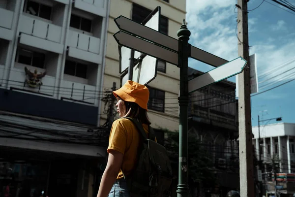 Yellow Backpacker Woman Green Backpack Standing Signpost Roadside Sunlight Summer — Stock Photo, Image