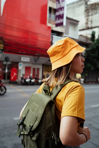 Backpacker Woman Yellow Clothes Green Backpack Standing Roadside Red Building — Stock Photo, Image