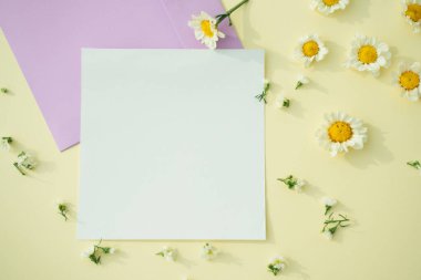 Beyaz, sarı arka planda çiçek olan kağıt maketi. Üst görünüm.