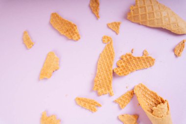 Kırık waffle külahı pembe arka planda. Boşluğu kopyala.
