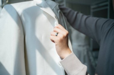 Bir adam gelinlik seçmek için düğün stüdyosunu ziyaret eder ve dener. Yüzük parmağında yüzük olan bir adamın kesilen eli tasmayı tutar..