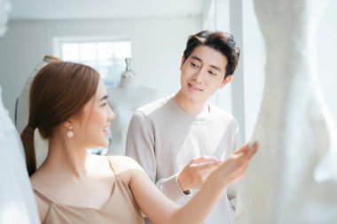 Bir çift gelinlik seçmek için düğün stüdyosuna gider. Bir erkek bir kadına gelinliği sorar..