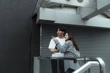 Siyah beyaz ekose elbiseli kız erkeğine bir şey görmesini söyle..