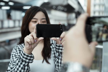 Genç çift, mutlulukla buluşurken birbirlerine fotoğraf çekiyorlar..