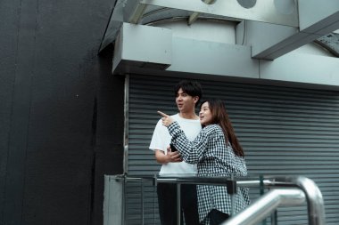 Siyah beyaz ekose elbiseli kız erkeğine bir şey görmesini söyle..