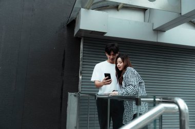 Siyah beyaz giysili bir bağırsak, barikattaki kız arkadaşına bir fotoğraf gösteriyor, bir kız tatmin oluyor..